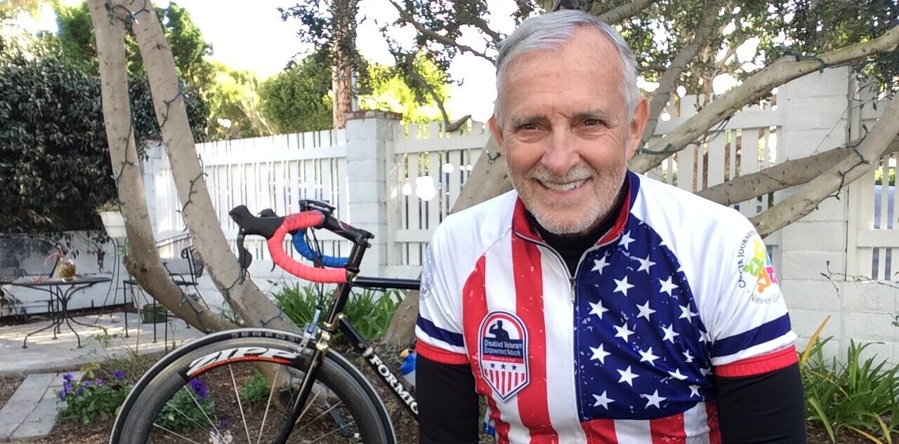 Image of Robert Hess smiling next to his cycle.